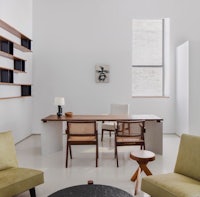 a white living room with a wooden table and chairs